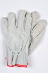 A pair of gray leather work gloves with red trim is shown on a white background