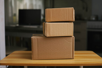 Three stacked cardboard boxes on a wooden table.