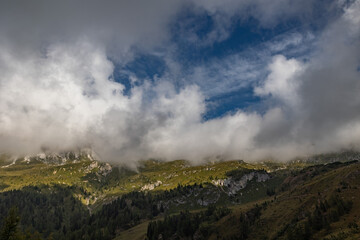 vista panoramica su un ambiente naturale di montagna, nell'Italia nord-orientale, in Veneto, di giorno, con cielo parzialmente nuvoloso, in autunno e con colori brillanti