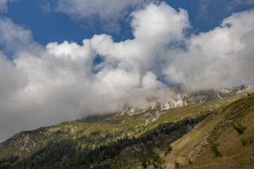 vista panoramica su un ambiente naturale di montagna, nell'Italia nord-orientale, in Veneto, di giorno, con cielo parzialmente nuvoloso, in autunno e con colori brillanti