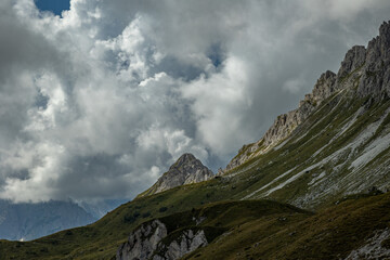 pendii erbosi e rocciosi in alta quota, in un ambiente naturale di montagna, nel nord Italia, tra Veneto e Friuli Venezia Giulia, di giorno, in autunno, con cielo nuvoloso