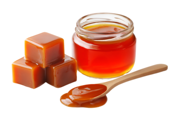 Delicious golden caramel candies and sweet liquid caramel sauce in a jar with spoon
