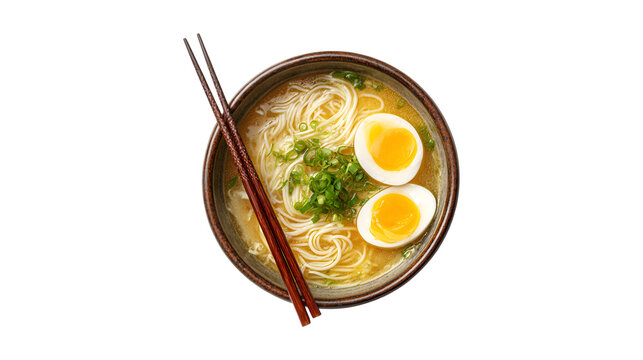 A delicious bowl of Japanese ramen noodle soup with soft boiled eggs and fresh green onions viewed from above with chopsticks resting on the side