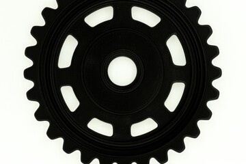 Black gear with symmetrical sprocket teeth on white background, front view with smooth surface and central empty space, minimal mechanical design ideal for industrial engineering