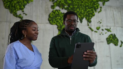 Two african american colleagues collaborating on tablet in modern office - Powered by Adobe