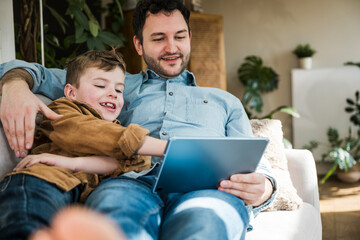 Father and son enjoying quality time together using a tablet indoors