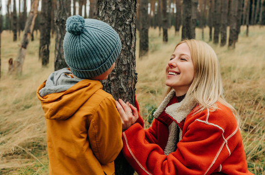 Mother and son relaxing together in an autumn pine forest