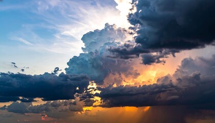 Dramatic sky dark storm clouds contrast bright sky above. Golden sunlight pierces through breaking clouds