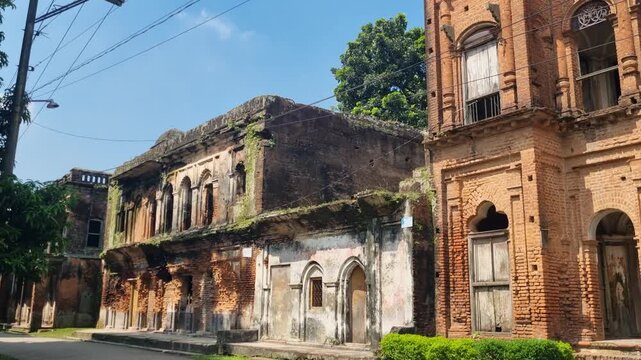 Ruins of British colonial-era mansions in Panam Nagar, Sonargaon, Bangladesh, slowly decaying under a bright blue sky, giving the ghost town a haunting, abandoned atmosphere