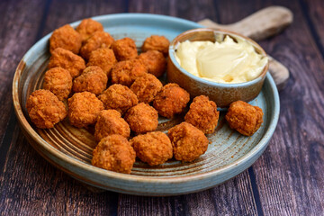 Crispy  deep fried   chicken  popcorn  nuggets and french fries . Breaded  with Cornflakes chicken  Breast fillets  with chilly peppers and fresh   basil on wooden rustic background
