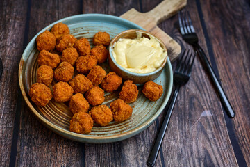 Crispy  deep fried   chicken  popcorn  nuggets and french fries . Breaded  with Cornflakes chicken  Breast fillets  with chilly peppers and fresh   basil on wooden rustic background