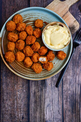 Crispy  deep fried   chicken  popcorn  nuggets and french fries . Breaded  with Cornflakes chicken  Breast fillets  with chilly peppers and fresh   basil on wooden rustic background