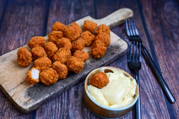 Crispy  deep fried   chicken  popcorn  nuggets and french fries . Breaded  with Cornflakes chicken  Breast fillets  with chilly peppers and fresh   basil on wooden rustic background