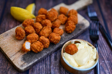Crispy  deep fried   chicken  popcorn  nuggets and french fries . Breaded  with Cornflakes chicken  Breast fillets  with chilly peppers and fresh   basil on wooden rustic background
