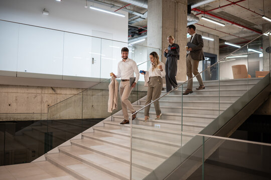 Business people walking down modern office stairs
