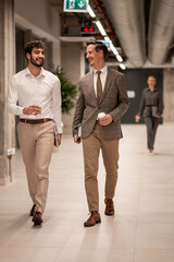 Businessmen walking and talking in office corridor