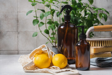 Eco friendly cleaning concept with glass bottle detergent, natural brushes and sponges on...