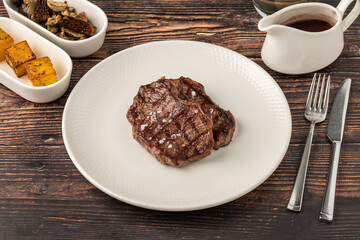 Juicy grilled beef steak served with sauce and sides
