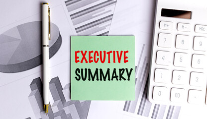 EXECUTIVE SUMMARY phrase on green paper with pen, charts and white calculator on desk 