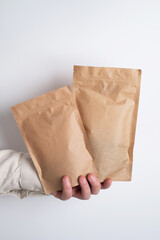 Kraft paper packaging in a mans hands. Packaging for coffee, cosmetics. Packing closeup. Product for sale. Online shopping. Boxes with surprise. Delivery service, shipping. Empty, mockup. Eco friendly