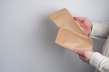 Kraft paper packaging in a mans hands. Packaging for coffee, cosmetics. Packing closeup. Product...