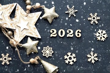 Rustic wooden Christmas decorations with stars, snowflakes, and the year 2026 on a snowy dark background.