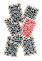 A hand of vintage playing card backs with one card in a different colour.