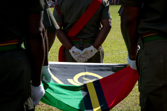 An honour guard carrying the flag of Vanuatu