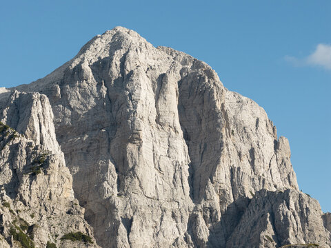 Aerial view of the stark, rocky peak of a mountain dominating the skyline under a clear sky, Teth, Shkoder County, Albania.