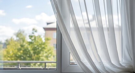 Obraz premium White sheer curtains framing a bright window with a peaceful outdoor view