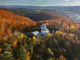 Aerial view of the Vartovka astronomical observatory nestled among the vibrant autumn foliage, a blend of science and nature's colorful display, Banska Bystrica, Banskobystricka kraj, Slovakia.