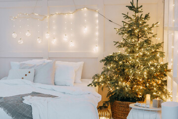 Obraz premium Tver, Russia-November 15, 2019. Embellished mirror, a large bed and a living Christmas tree with lights. New year's interior in bright colors, festive atmosphere, decor, garlands, gifts.