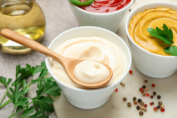 Different sauces, spices and herbs on light table, closeup