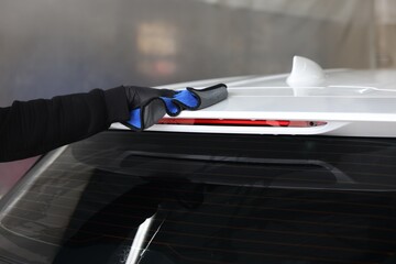 Man wiping auto with rag at car wash, closeup