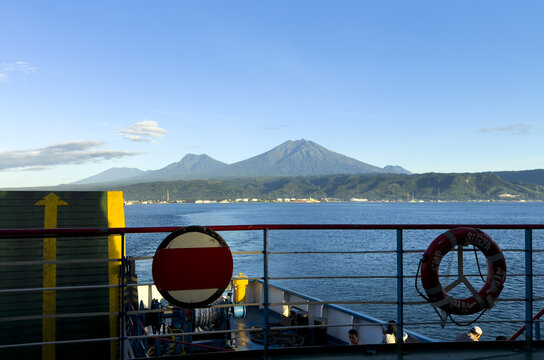 View of deep blue sea stretching out to meet distant mountains under a bright sky from the deck of a boat, Banyuwangi, East Java, Indonesia.