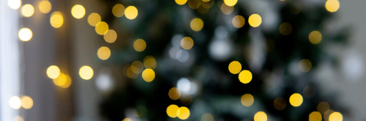 Blurred Christmas tree lights with golden bokeh. Festive holiday background. New Year celebration and winter season decoration.