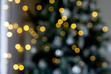 Christmas lights bokeh effect with festive golden yellow glow. Abstract holiday background for greeting card. Winter celebration mood.