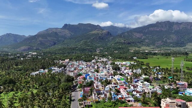 This stunning drone shot perfectly illustrates the harmony between community and nature in the Western Ghats. A town thrives where the plains meet towering mountains, embodying ecotourism.