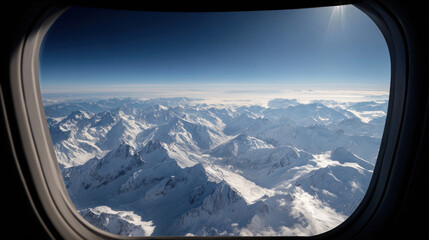 Aerial view of snow-capped mountains seen from an airplane window on a clear day. Photo captures stunning view of snow-covered mountains from airplane window, under clear blue sky, perfect for travel