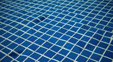 Blue tiles under rippling water form an abstract grid pattern