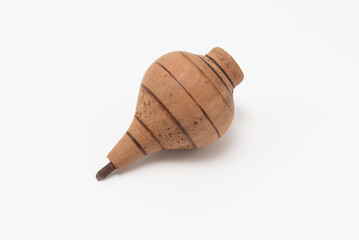Vintage wooden spinning top with painted lines, isolated on a clean white background. Studio shot. Symbolizes childhood, toy, nostalgia, and simple games.