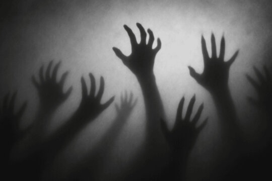 Shadow overlay effect for halloween background with Terrifying scary hands with long nails,Creepy monster claw,silhouette of hands,zombie hand rising out of a graveyard