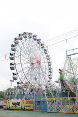 Closeup of multi-coloured Giant Wheel during Dussehra Mela in Delhi, India. Bottom view of Giant Wheel swing. Ferris wheel with colourful cabins during evening time.