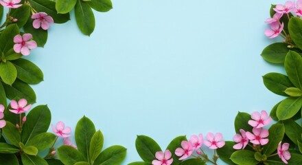 Fototapeta premium Floral frame of green leaves and small pink flowers on light blue background