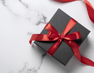 Luxurious matte black gift box with a rich, glossy red silk ribbon and bow, presented on an elegant white and gray marble surface; premium holiday or anniversary gifting concept