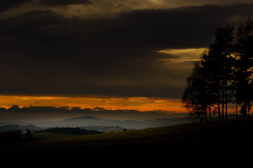 Dramatic sunset over rolling hills and distant mountains