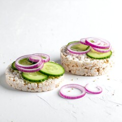 Two crispbread rounds topped with cucumber and red onion slices