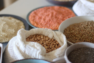 Bowls and bags full of various healthy grains and legumes. Selective focus.