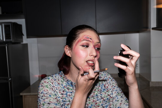 Artistic woman adding final touches to Halloween makeup look