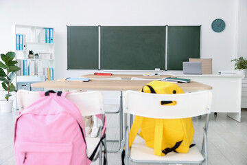 Green chalkboard, desks and chairs in classroom. Mockup for design